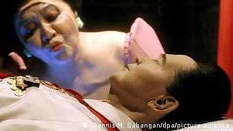 Imelda Marcos küsst Glassarkophag ihres verstorbenen Gatten