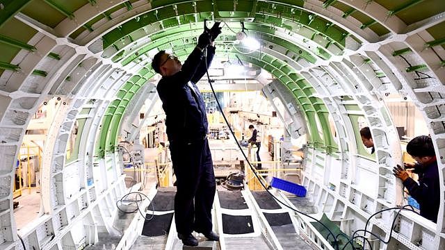 Employees work on the production line of components for Airbus A220 aircraft at a workshop of AVIC SAC Commercial Aircraft Company