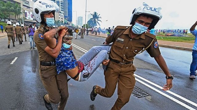 斯里兰卡警察抬着抗议者