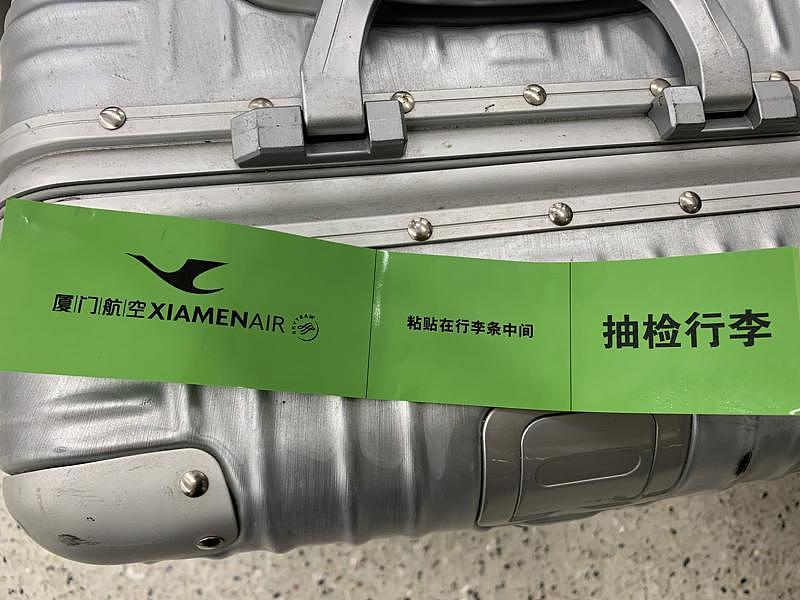 陈女士的托运行李箱上被贴上绿色标志，上面有「抽检行李」字样。 （陈女士提供）