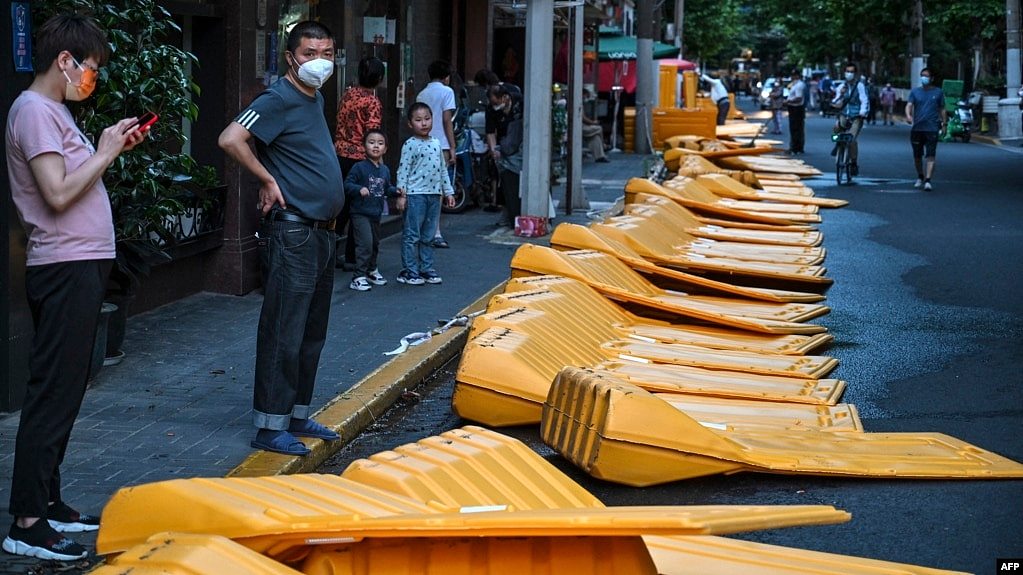 上海市民站在刚刚被推倒的用于封城的围栏旁。（2022年5月31日）