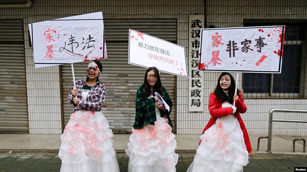 资料照- 在“国际消除暴力日”这天，三名中国女大学生打扮成家暴受害者，手举反对暴力、反对家暴的标语牌，在武汉民政局外举行抗议。