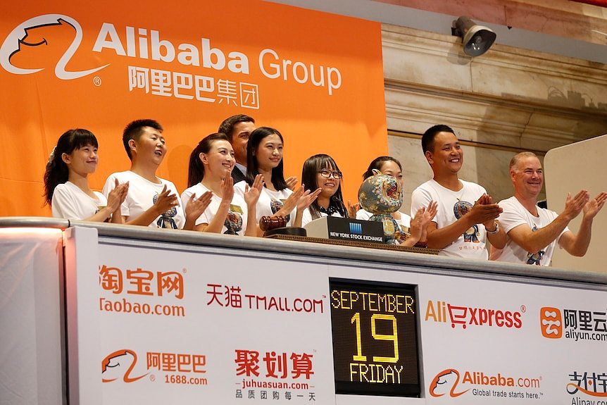 Alibaba employees applaud as the opening bell of the New York Stock Exchange is rung