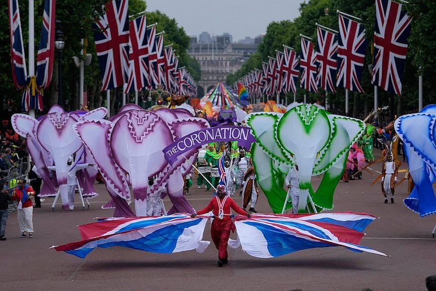 People parade in brightly coloured costumes during the Platinum Jubilee Pageant outside Buckingham Palace in London.