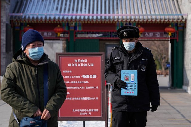 2022年1月25日在北京一个公园入口处手持健康码通知的一名保安（美联社图片）