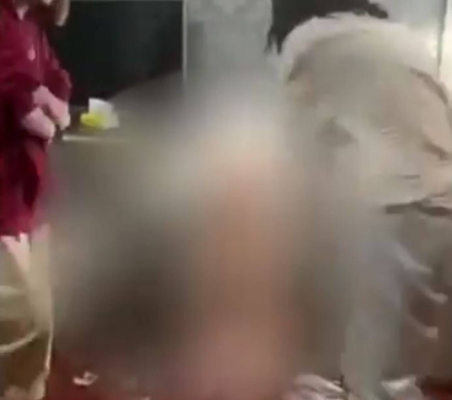网传影片显示，被打女子衣服被脱光跪在地上，一旁则有两名女子不断对她掌掴。 （影片截图）