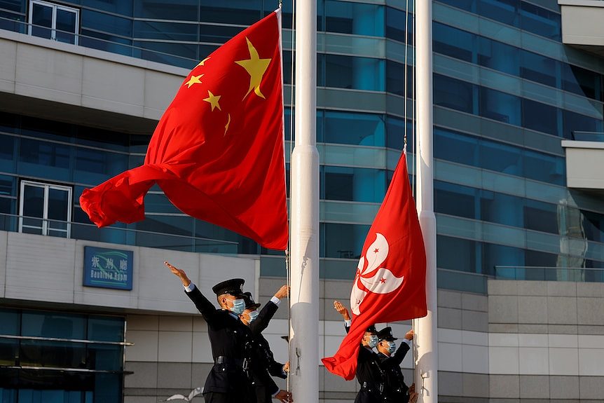 中国和香港的旗帜在一栋楼前飘扬