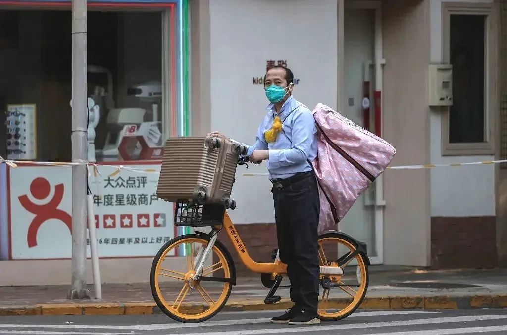 5月9日，上海，一名从方舱医院出院的市民带着行李骑车回家。