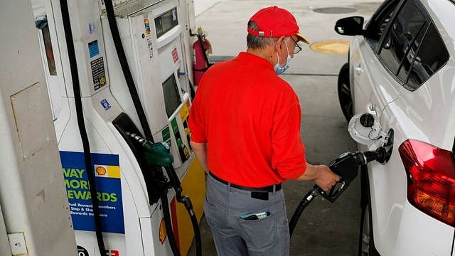 A worker fills up a car with gas outside the Holland Tunnel at the start of the Memorial Day weekend, under rising gas prices and record inflation, in Newport, New Jersey, U.S., May 27, 2022