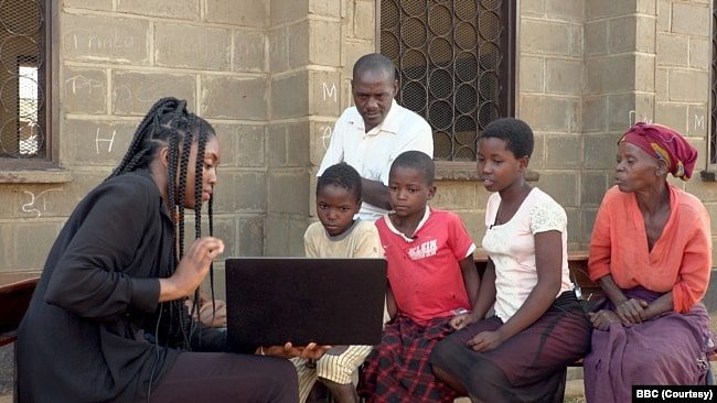 英国广播公司BBC记者鲁纳科·塞利纳向马拉维孩子展示“黑鬼”视频（BBC授权使用）