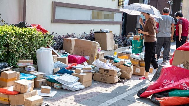 居民在小区外收集快递包裹