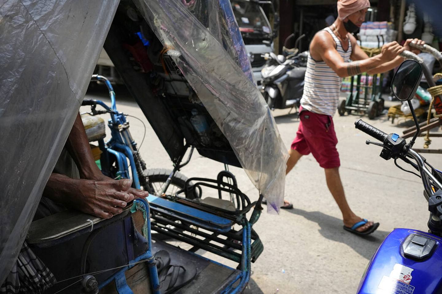 图为6月16日，菲律宾马里拉街头上，有嘟嘟车之称的三辆车司机生计受通胀压力大受影响。 （AP）