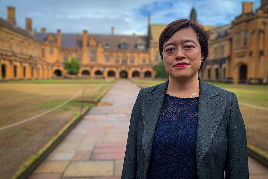 A woman stands on a uni campus.