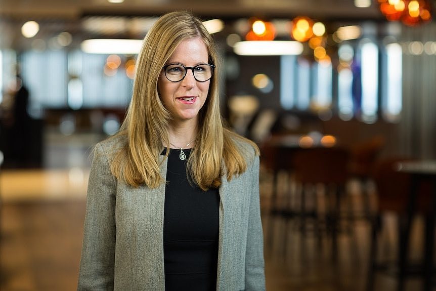 A woman stands in a lobby.