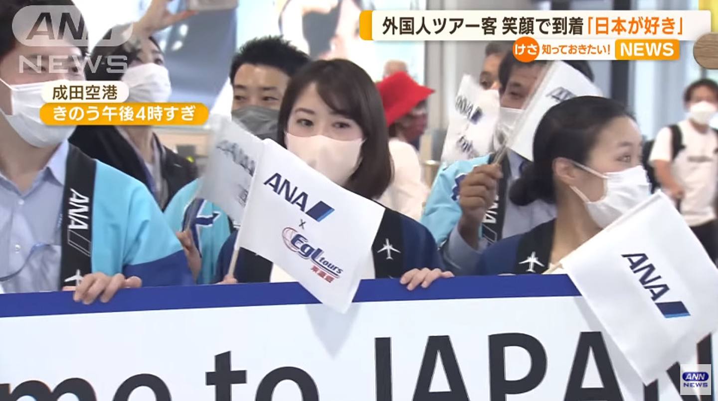 成田机场有大量拿着旗仔和横额的机场职员迎接（YouTube：@ANNnewsCH 截图）