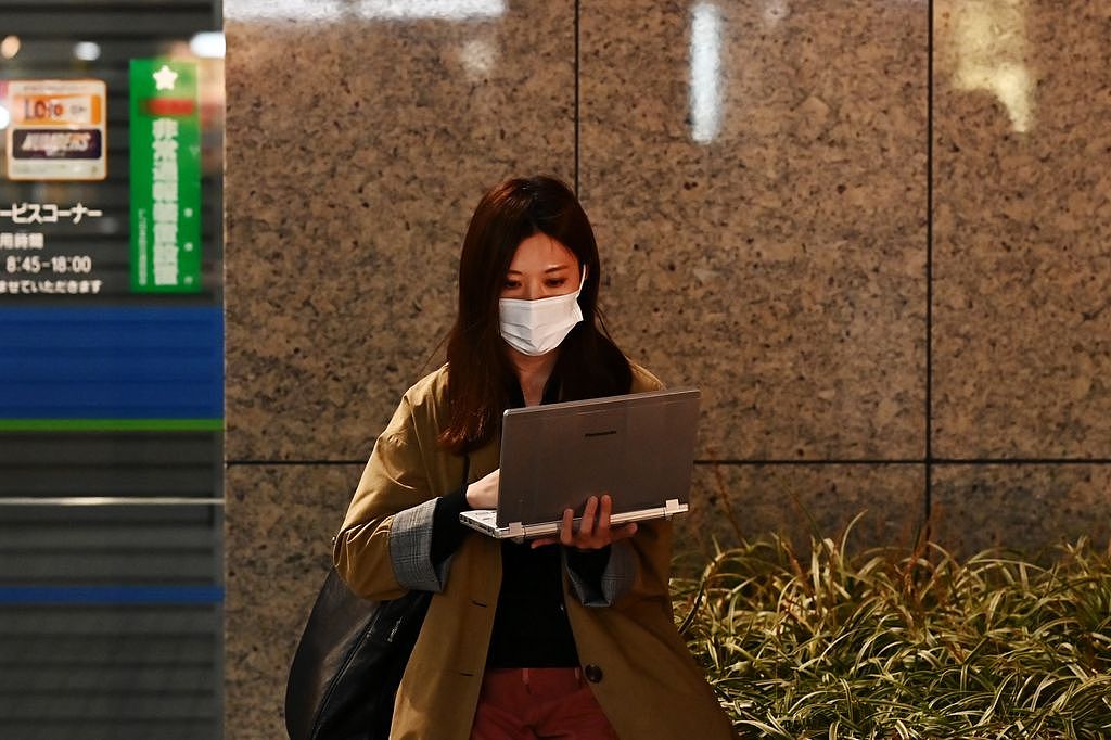 图为日本东京一名女子在路边使用电脑，非当事人。 法新社