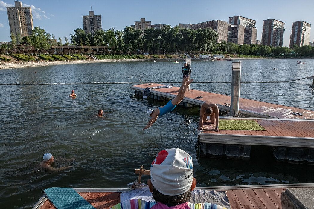 游泳者在北京市中心的一个湖中游泳。
