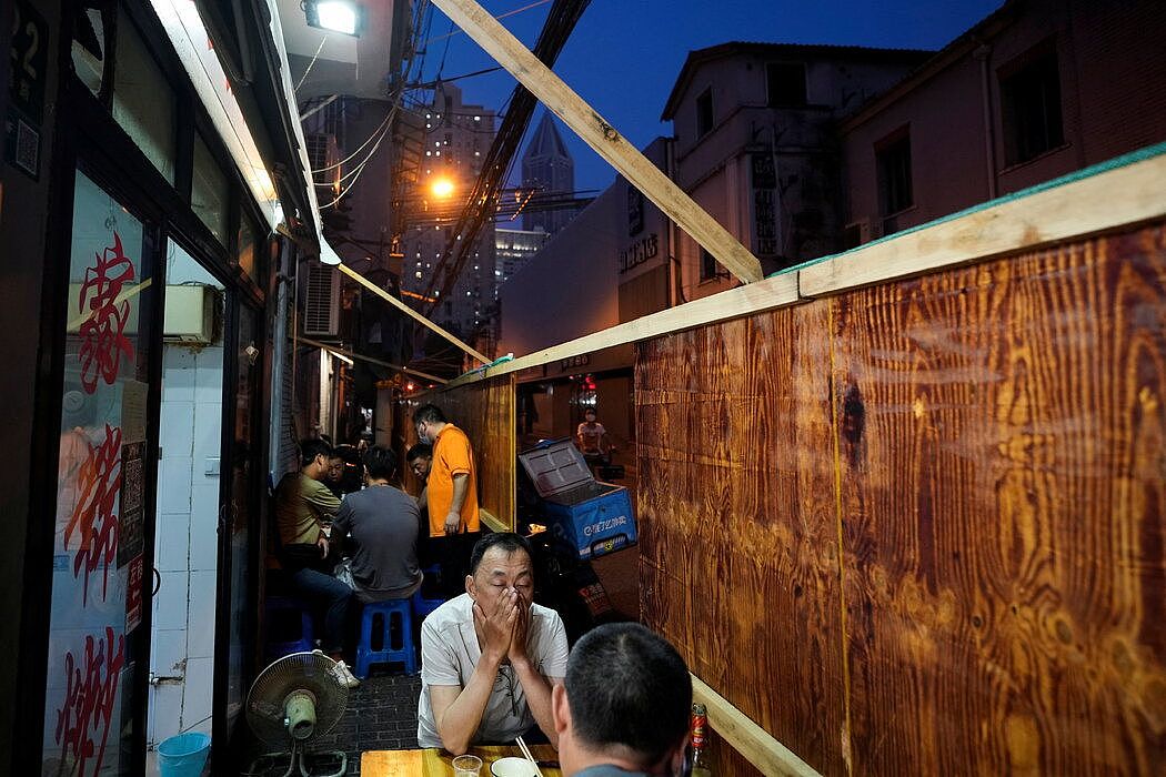 上海，晚上外出就餐的民众，摄于本月早些时候。照片中仍可看到封锁居住区的栅栏，即使在上海放松了全城的封控之后，当局仍在对市内部分地区采取新的限制措施。