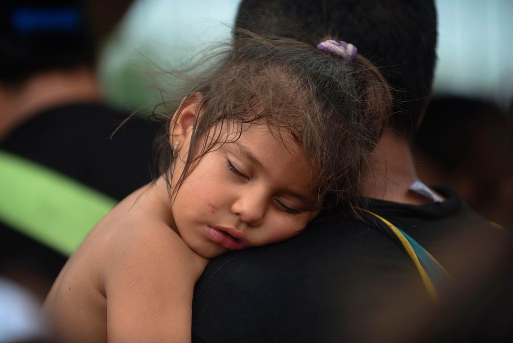 睡眠充足对心脏健康很重要；图为一名宏都拉斯女童在家人怀中酣睡。 法新社