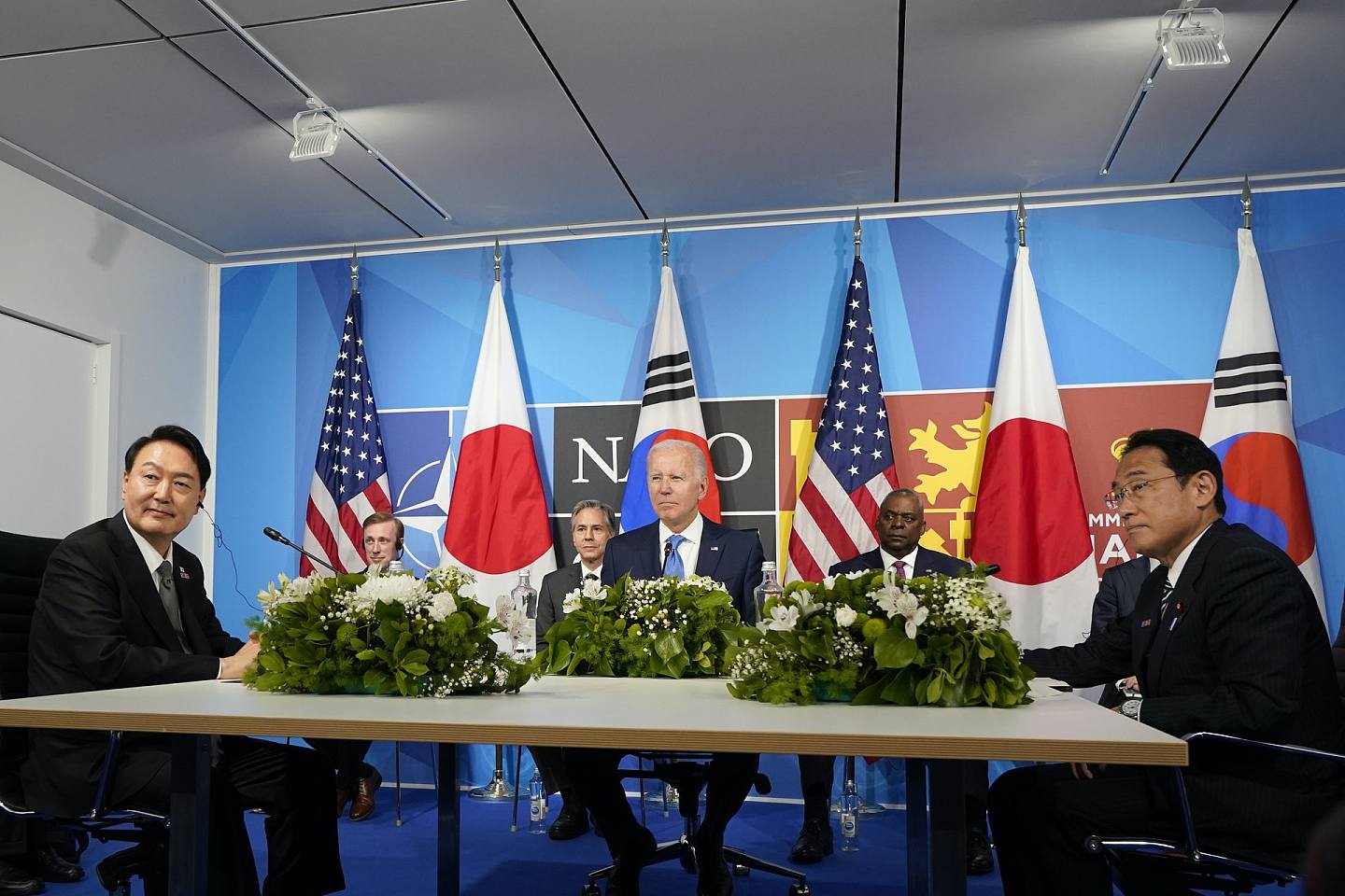 美国总统拜登（中）、韩国总统尹锡悦（左）、日本首相岸田文雄（右）6月29日在马德里北约峰会期间，举行三国首脑会谈。 坐在拜登后面的官员分别是白宫国家安全顾问沙利文、国务卿布林肯及防长奥斯汀。 （AP）