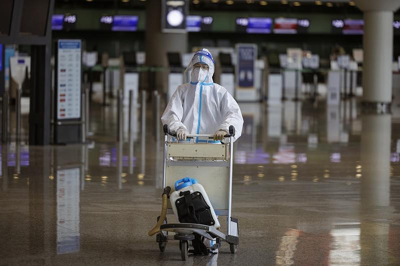 上海疫情趋缓，民众恢复旅行。 图为虹桥机场1名旅客穿着全套防护装。 (欧新社)