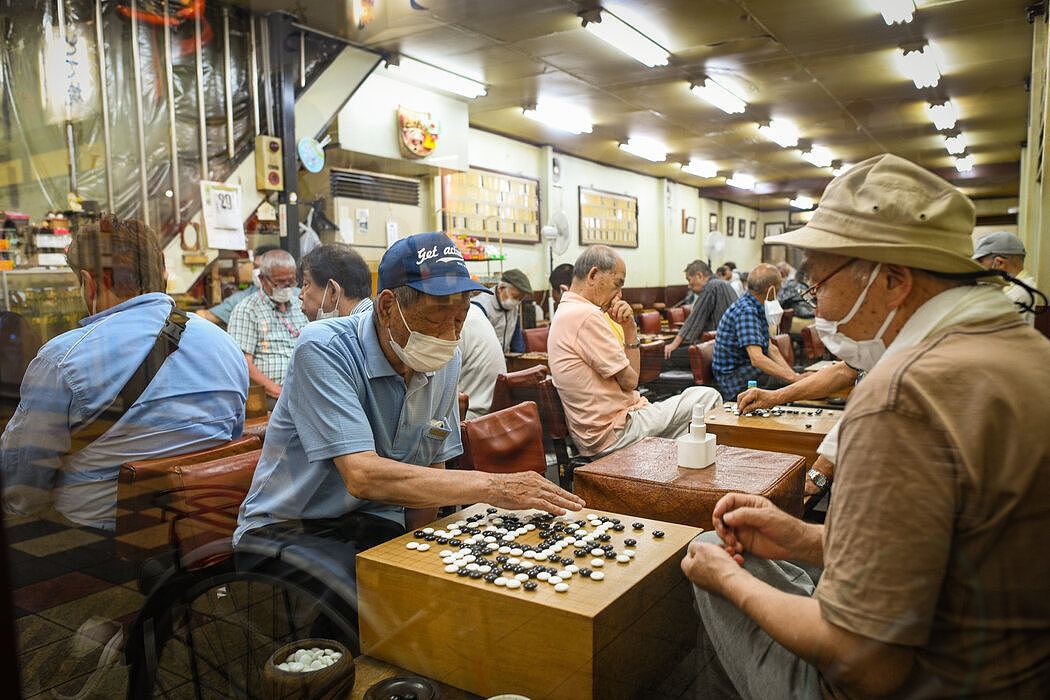 在大阪的一家棋牌室下围棋。棋牌室老板伊达利雄说，经常有陌生人责怪他接待太多客人。