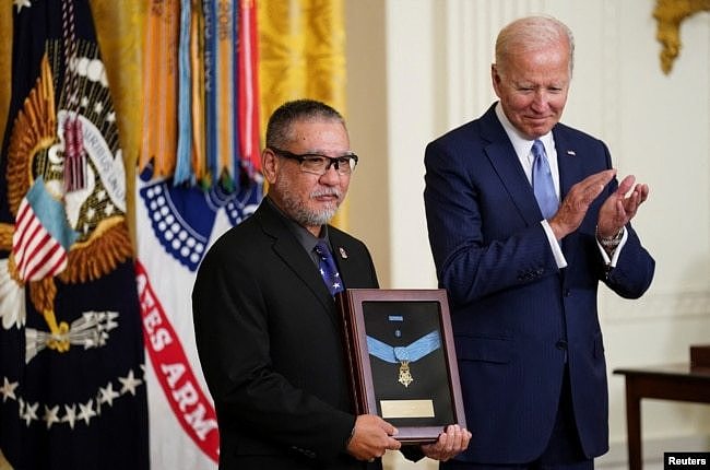 拜登总统在白宫把追赠给美国老兵爱德华·金城的荣誉勋章交予金城的儿子约翰·金城。(2022年7月5日)