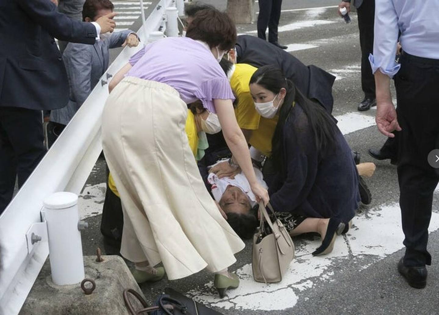 日本前首相安倍晋三（中）在奈良市的街头演讲中被可疑男子袭击并倒在街上。 （AP）
