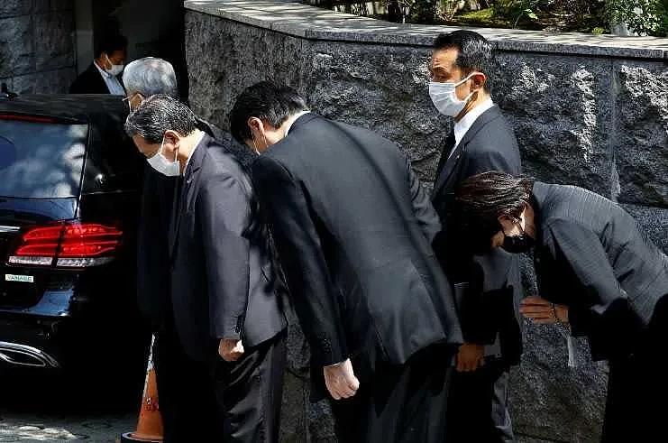 安倍晋三移灵车位刚刚返回东京，他生前力挺的自民党议员高市早苗（右），人就在东京宅邸前，对安倍灵车鞠躬致意。 （图／路透社）