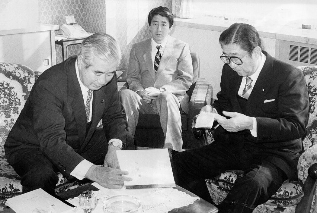 1988年，安倍晋三（中）和他的父亲安倍晋太郎（右）在一起，后者是自民党内的重要人物。1982年，年轻的安倍晋三作为父亲的行政助理开始了他的政治生涯。