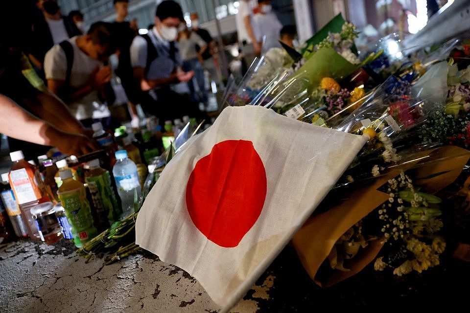 日本民众在安倍遇刺地点献花，并放置日本国旗。 路透