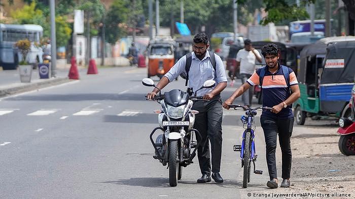 Sri Lanka | Ein Motorradfahrer schiebt sein Motorrad 