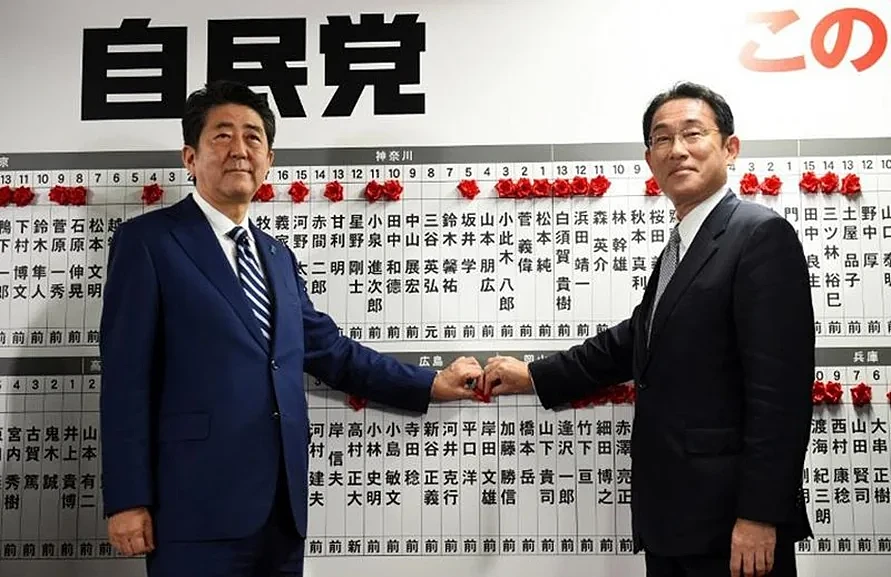 2017年，时任日本首相兼自民党领袖安倍晋三（左）与该党政策研究委员会主席岸田文雄（右）在东京党总部的董事会上。当时的岸田曾明确表达他对安倍的支持 图/法新社