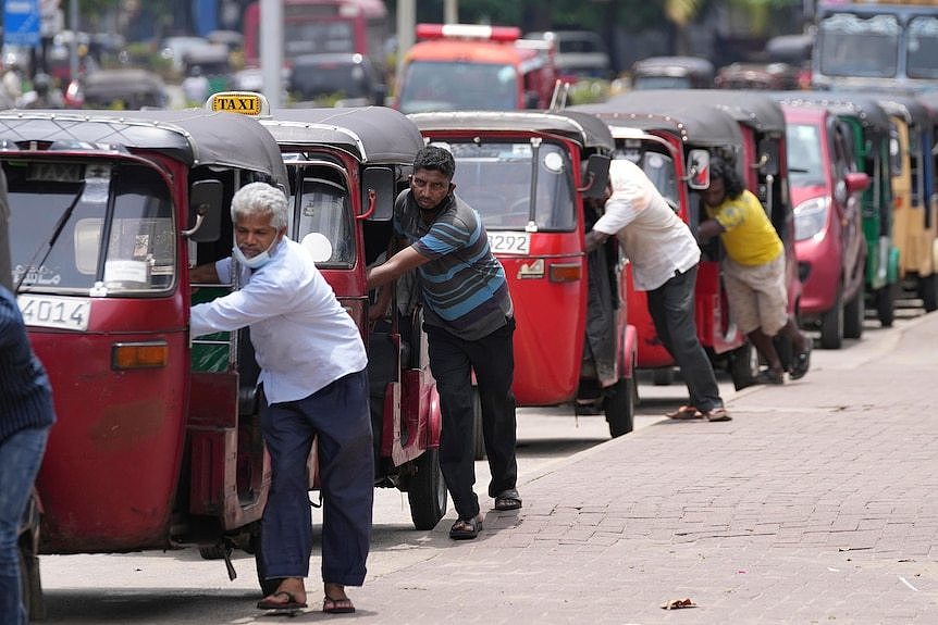 Sri Lankan auto rickshaw drivers queue up to buy petrol near a fuel station in Colombo, Sri Lanka