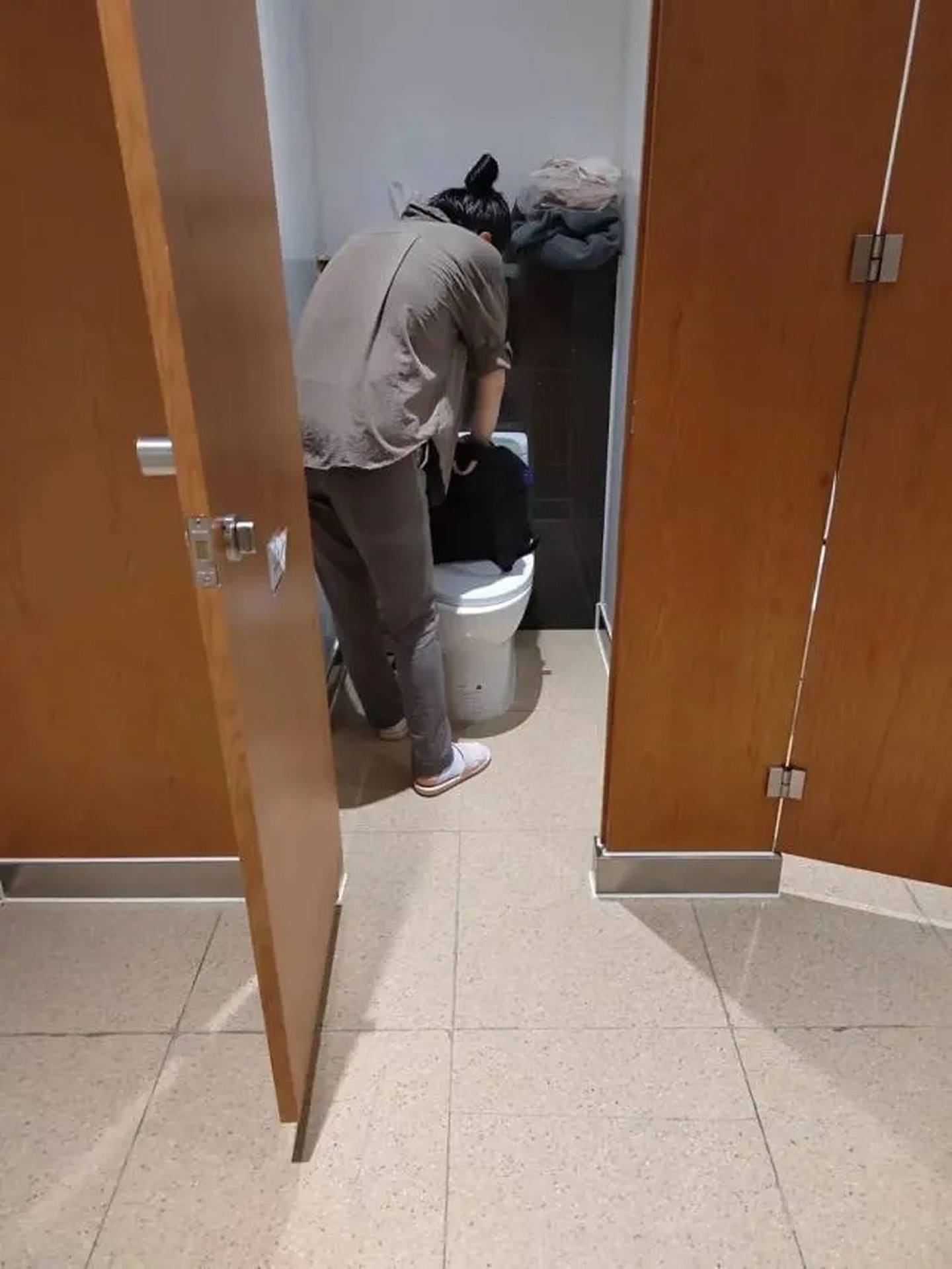 阿芬躲在上海虹桥火车站洗手间。 （腾讯）