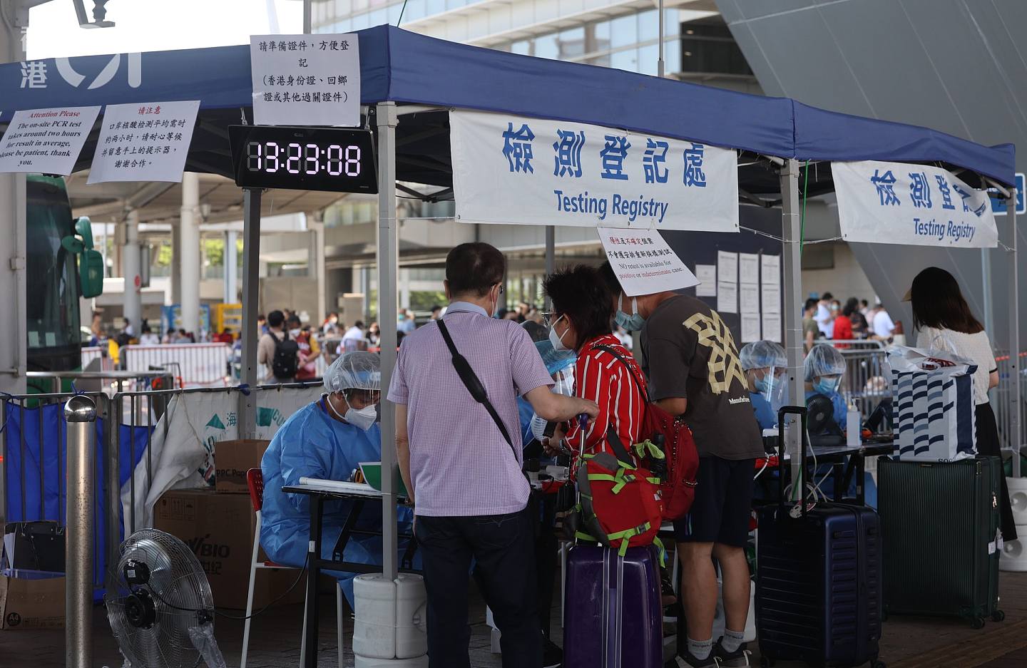 7月13日，深圳湾口岸继续有大量旅客出境，他们需在口岸即场做核酸检测，阴性才可通行。 （余俊亮摄）
