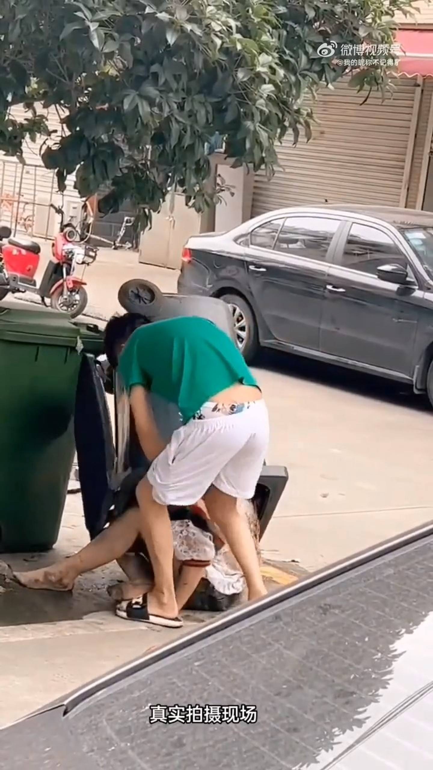 内地网络近日疯传段男子当街殴打女子影片，女子一度被强塞入垃圾桶。 （影片截图）