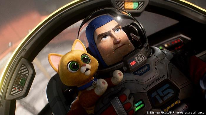 光年（皮克斯）的电影剧照：动画角色巴斯光年坐在宇宙飞船驾驶舱里的一只猫 Sox 旁边