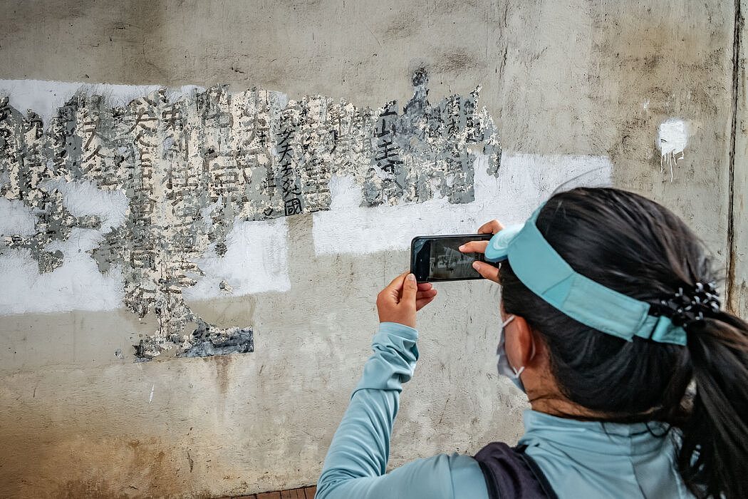 给新发现的字迹拍照。“‘九龙皇帝’的作品在香港所剩不多，我们现在能看到的都非常珍贵，”艺术家团体“怀疑人生就去”在庆祝这一发现时写道。