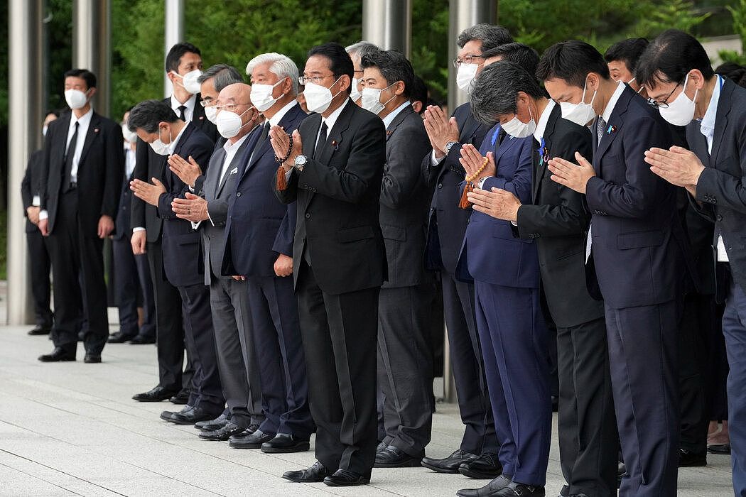 周二，日本首相岸田文雄（中）和其他官员在他的东京办公室外，载着安倍晋三遗体的灵车在那里短暂停留。