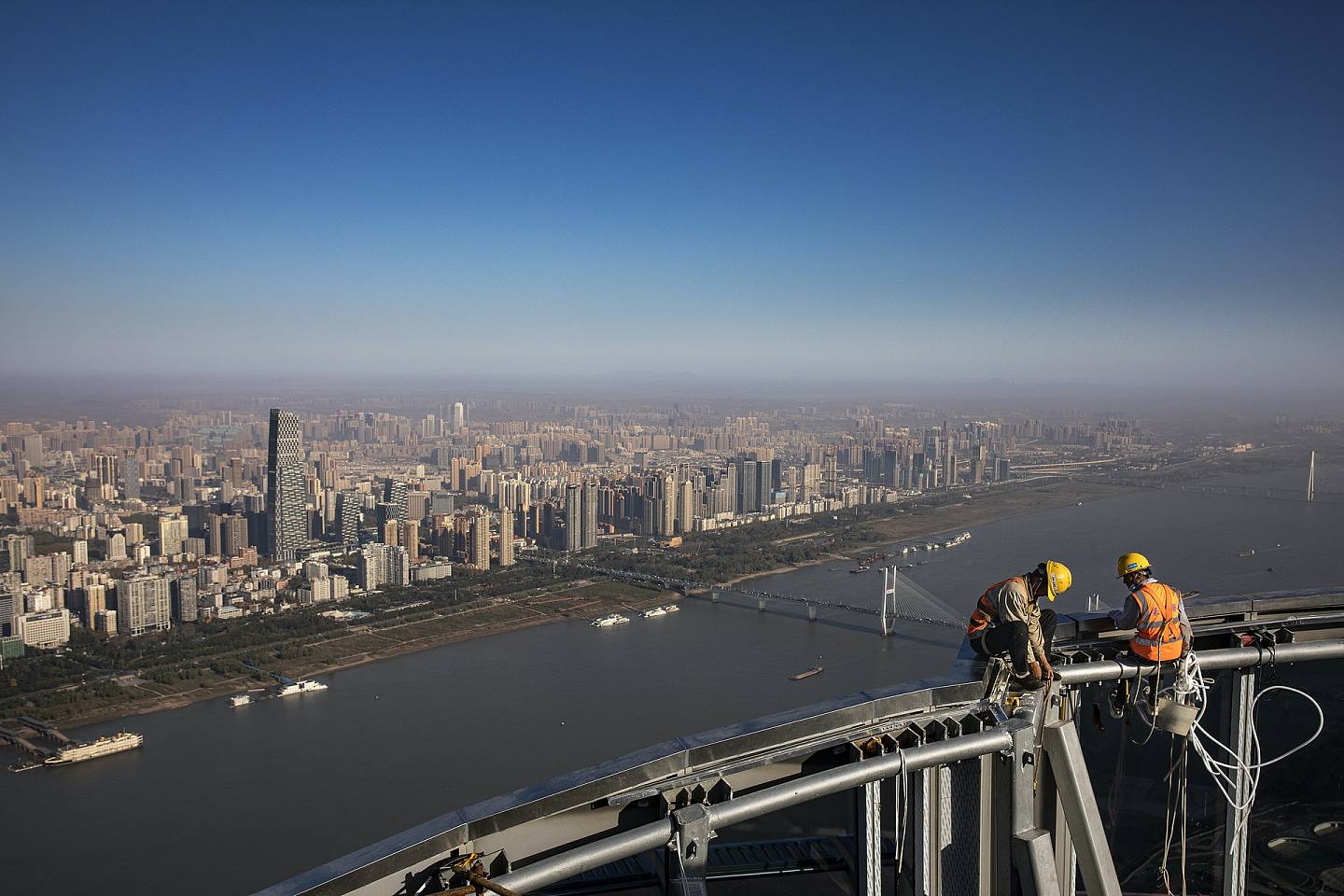 2021年11月15日，在湖北省武汉市的武汉绿地中心的楼顶上可以看到建筑工人。 武汉绿地中心将成为华中地区第一高楼，预计2022年竣工，高约476m，为全球第15高楼。 （Getty Images）