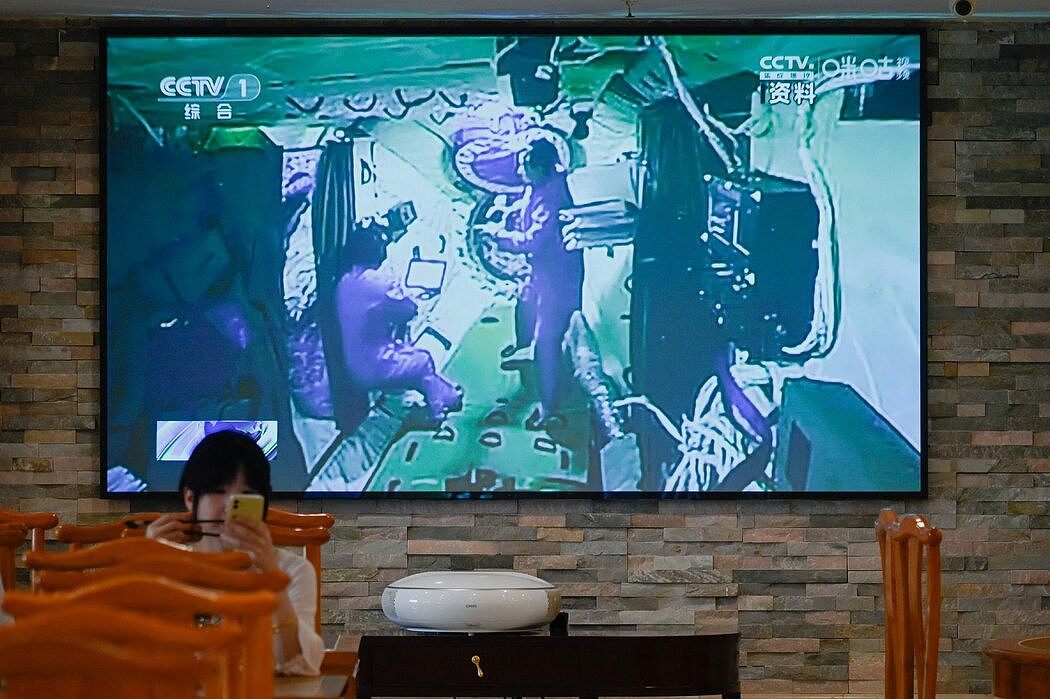 北京一家餐馆的电视屏幕上，中国航天员去年在天宫空间站的画面。