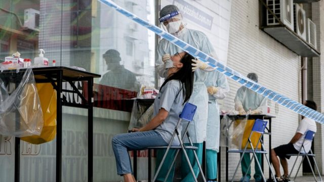 澳门某新冠病毒核酸检测采样点一位工作人员给一位女士采样（19/6/2022）