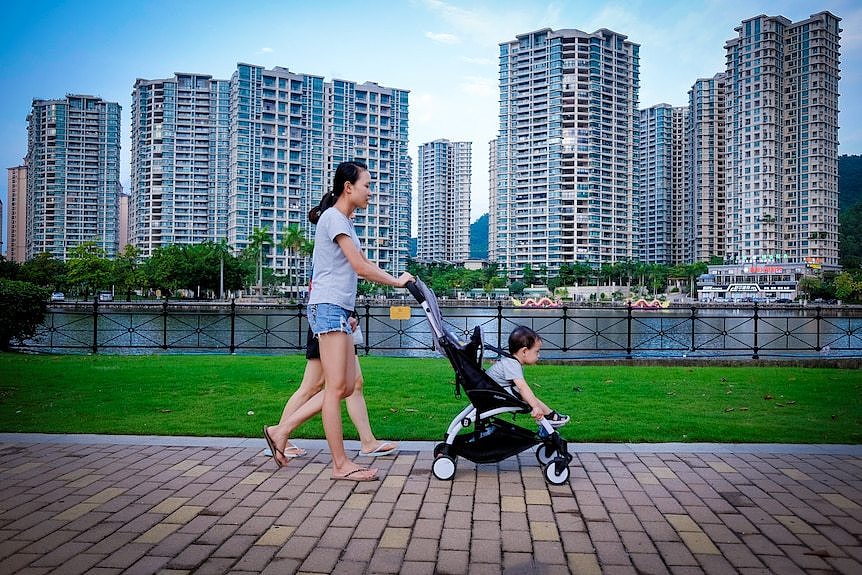 在中国，人们走过一个住宅地产开发项目。