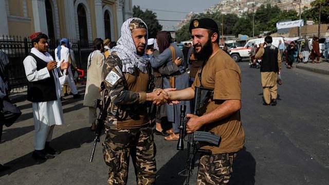 Taliban fighters greet each other outside the Shah-e Doh Shamshira Mosque, on the first day of Eid al-Adha, in Kabul, Afghanistan, 9 July, 2022