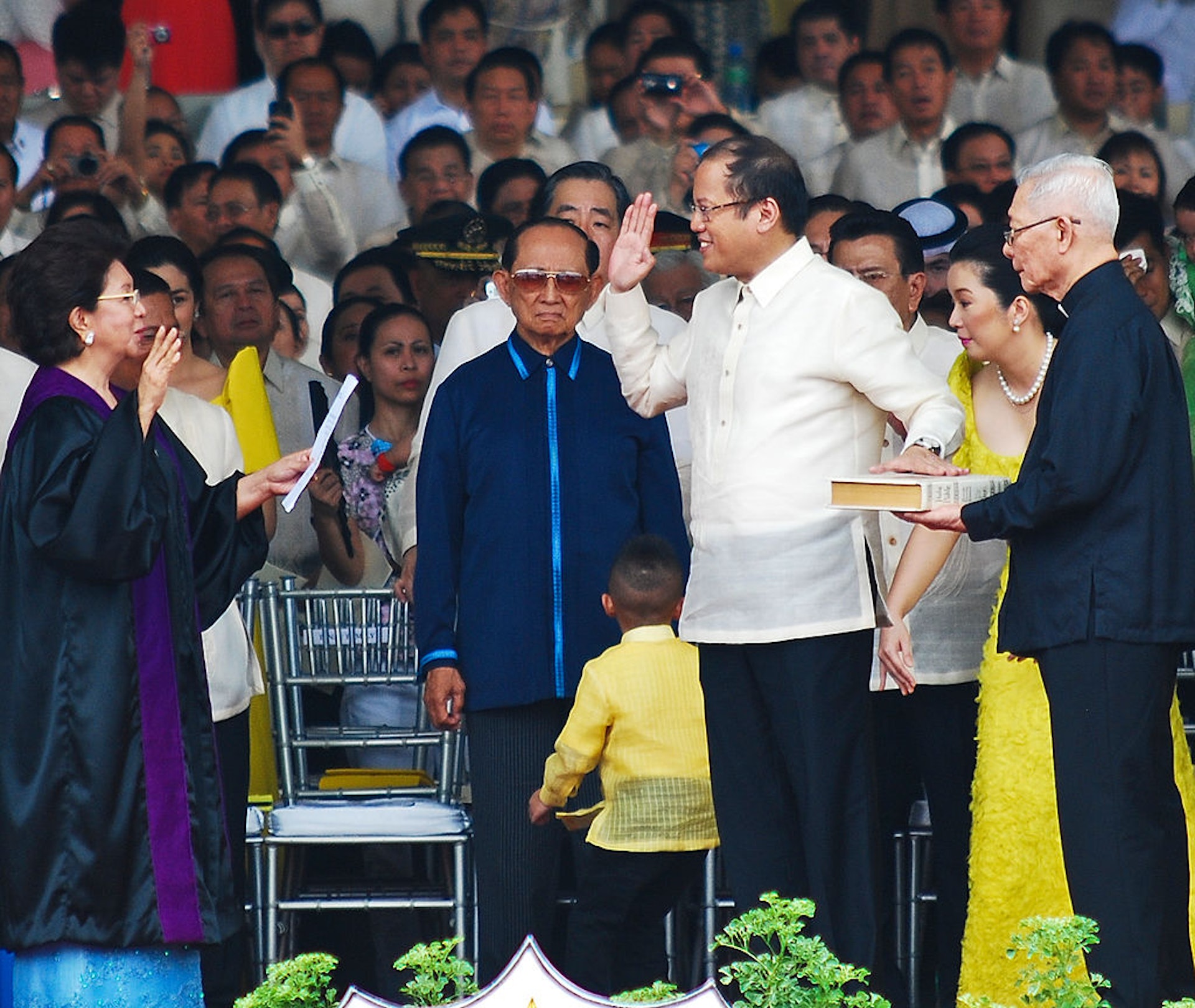 图为2010年6月30日，菲律宾前总统拉莫斯（图中第二排穿深蓝外套者）出席菲律宾前总统阿基诺三世（Benigno Aquino III，穿白衣黑裤者）的就职礼。 阿基诺三世2021年6月24日逝世。 （Getty）