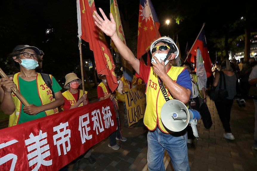 抗议者在美国众议院议长南希-佩洛西本应在台北下榻的酒店外高喊口号