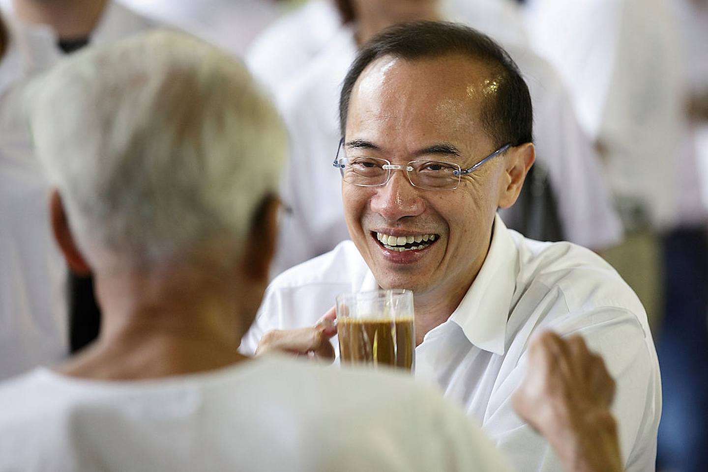 图为2011年5月2日，新加坡人民行动党阿裕尼集选区领军人物、前外长杨荣文在选区落区前，与一名居民一同喝咖啡。 2011年5月7日新加坡举行第11届国会选举。 （Getty）