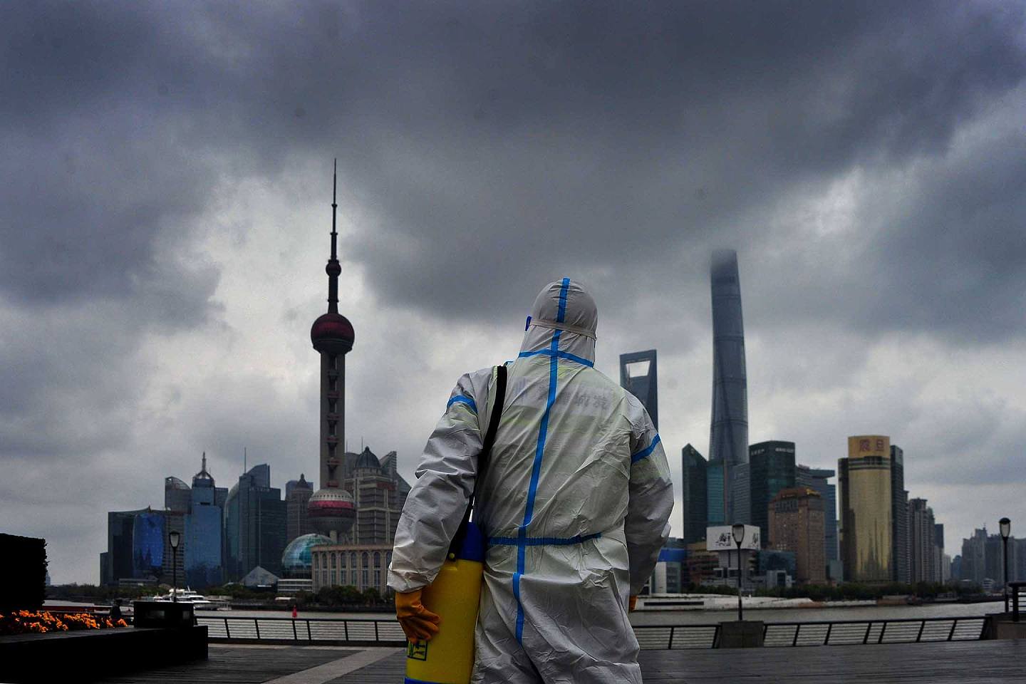 2022年3月31日，上海，一名身穿防护衣的工人在上海的外滩进行消毒。