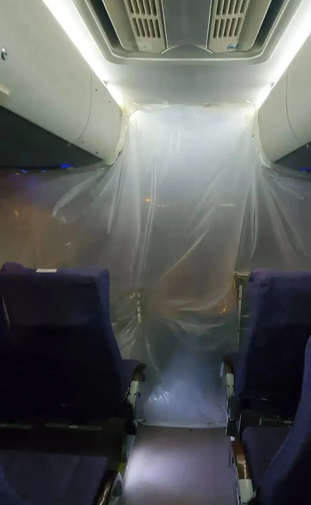 运送从三亚返西安游客的机场大巴车用塑料布将游客与驾驶员隔离。